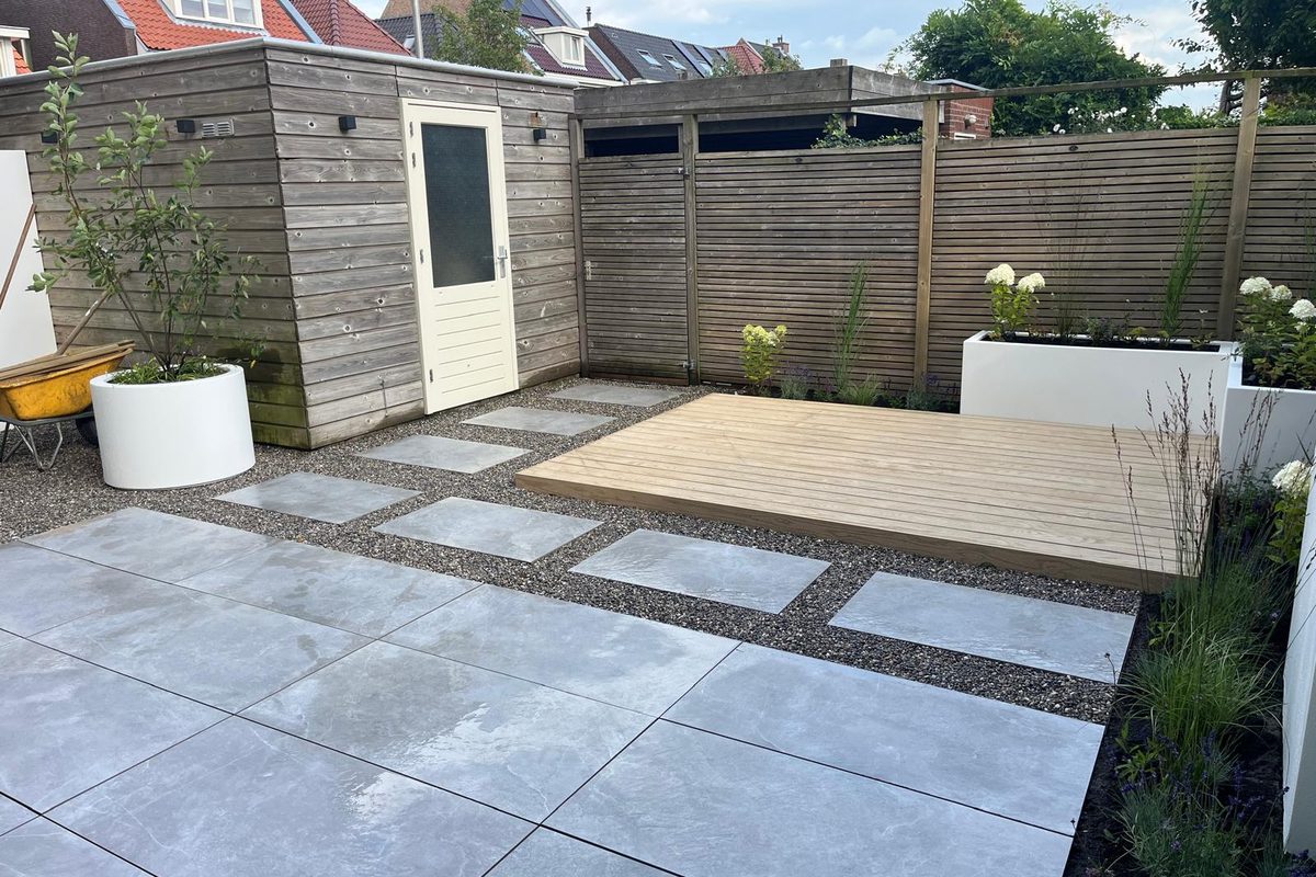 Witte polyester plantenbakken en wand op een terras met tegels