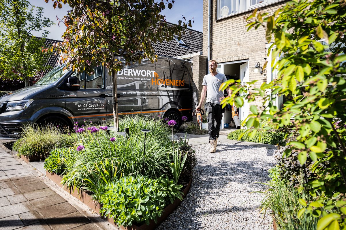 Bedrijfsbus van Derwort Hoveniers bij een onderhouden voortuin