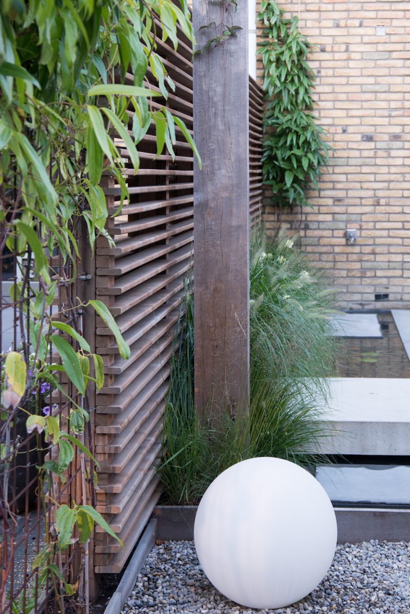 De aangelegde tuin met bollamp en lamellen